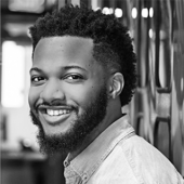 A photo of Joshua turning his head to and smiling.